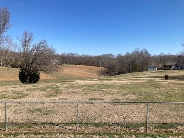 view of yard with a rural view and fence