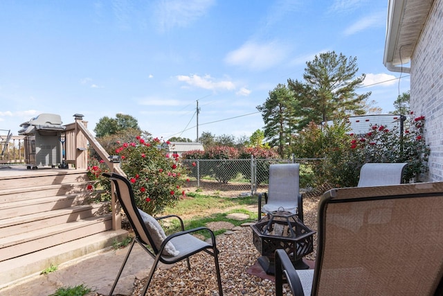 view of yard with a deck, an outdoor fire pit, fence, and stairway