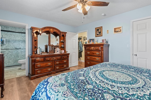 bedroom featuring connected bathroom, ceiling fan, a textured ceiling, and wood finished floors