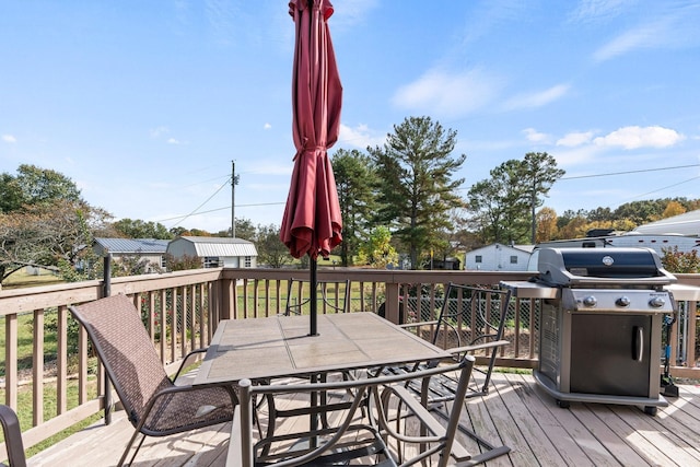 wooden deck featuring outdoor dining space and area for grilling