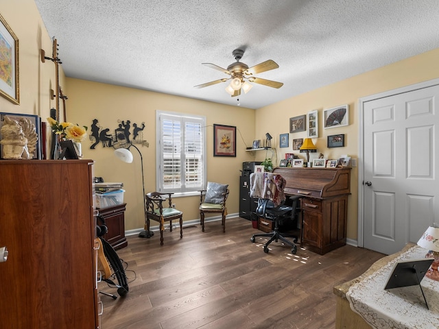 office space with ceiling fan, a textured ceiling, baseboards, and dark wood-type flooring