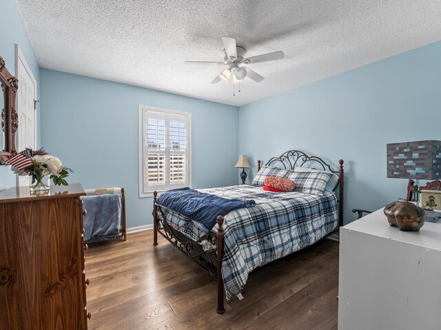 bedroom with a textured ceiling, a ceiling fan, and wood finished floors