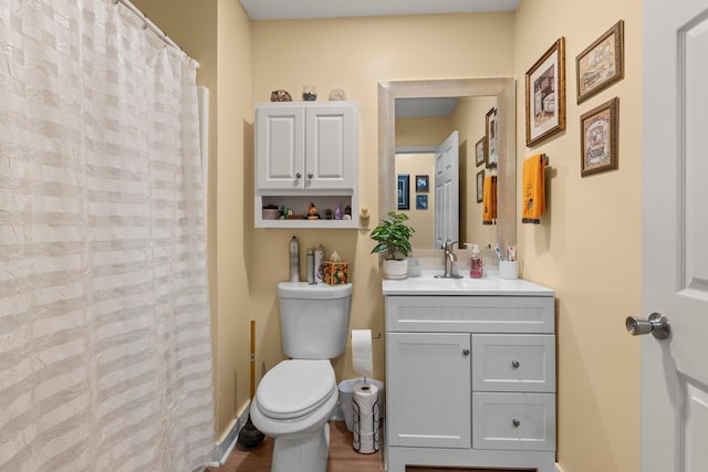 bathroom featuring curtained shower, baseboards, vanity, and toilet