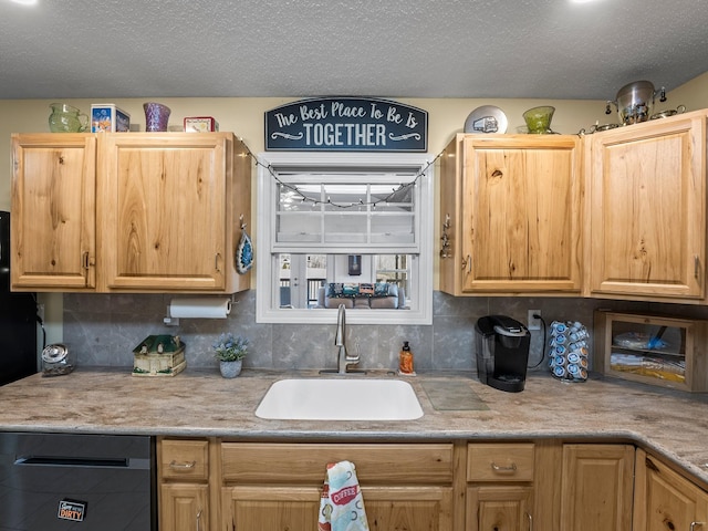 kitchen with a textured ceiling, a sink, black dishwasher, light countertops, and decorative backsplash