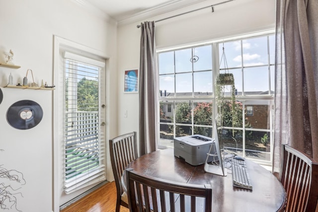 dining area with wood finished floors and crown molding