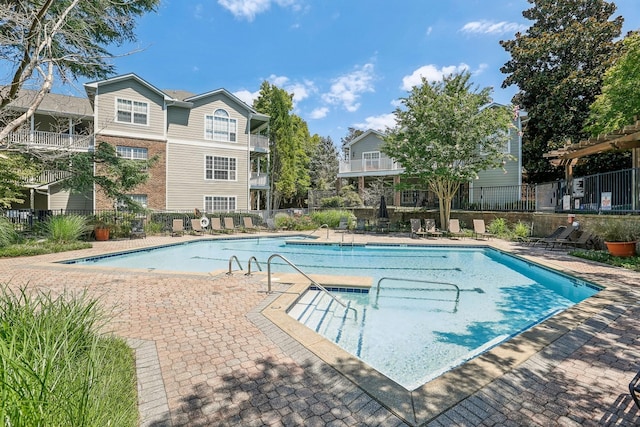 community pool featuring a patio area and fence