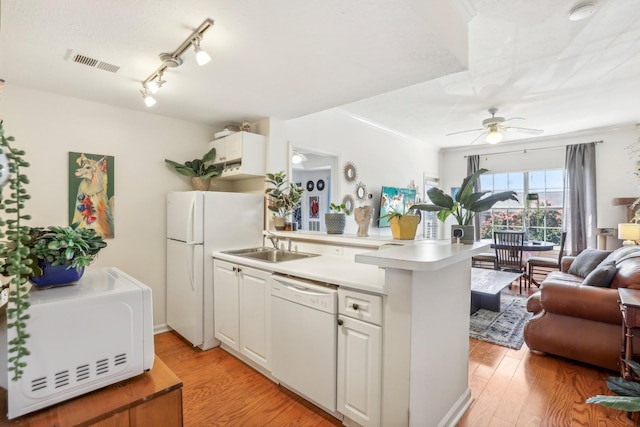 kitchen featuring white appliances, visible vents, light wood-style floors, open floor plan, and light countertops