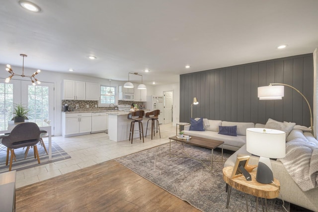 living area with a chandelier, recessed lighting, and light wood-style flooring