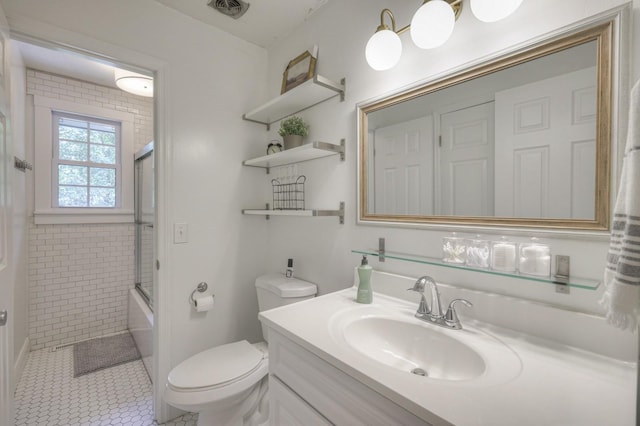 bathroom featuring visible vents, toilet, shower / bath combination with glass door, tile patterned floors, and vanity