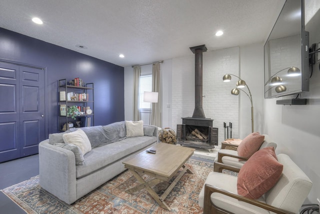 living room with recessed lighting, a wood stove, and a textured ceiling