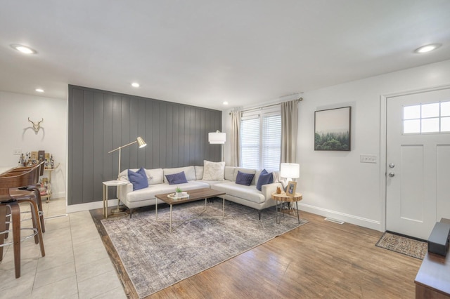 living area with light wood-style floors, visible vents, baseboards, and recessed lighting