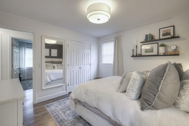 bedroom featuring dark wood-style floors, a textured ceiling, and a closet