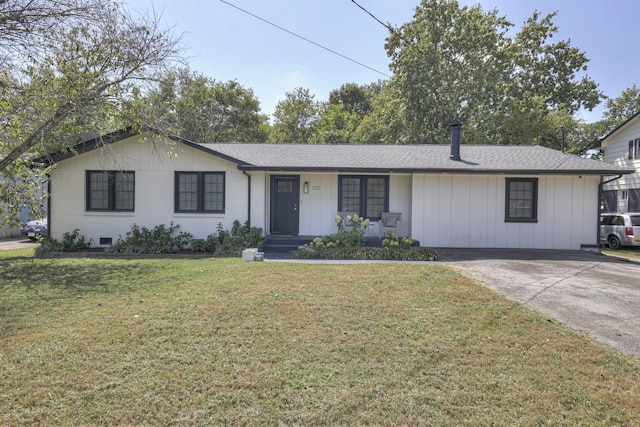 single story home featuring board and batten siding, a front yard, concrete driveway, and brick siding