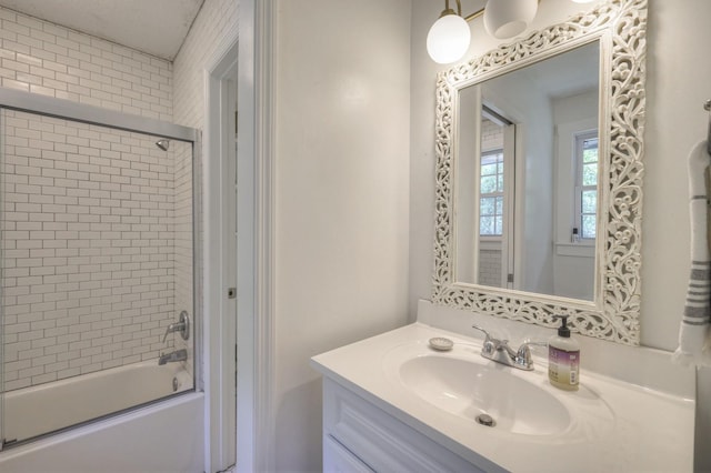 bathroom featuring combined bath / shower with glass door and vanity