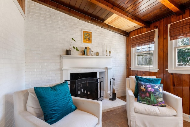 living area featuring a fireplace with raised hearth, wood ceiling, wooden walls, brick wall, and tile patterned flooring