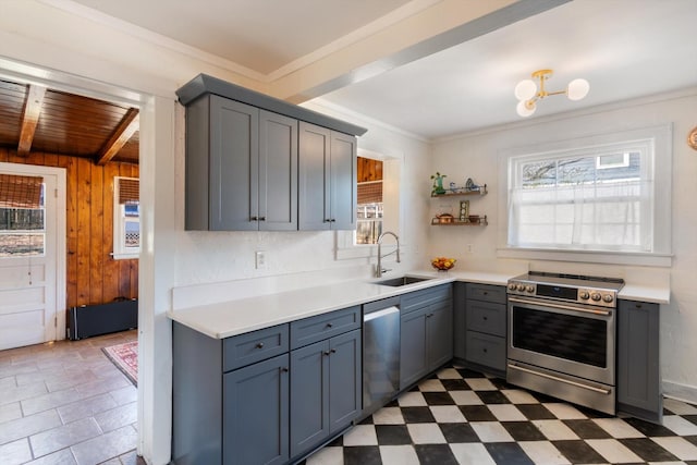 kitchen with stainless steel appliances, dark floors, light countertops, and a sink