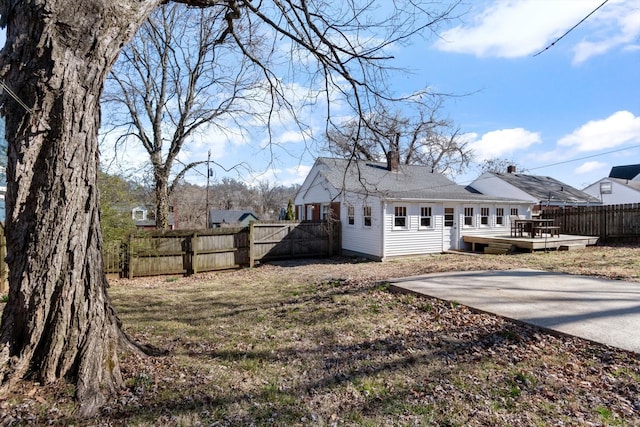 rear view of house featuring fence, a deck, and a yard