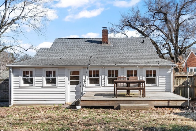 back of property featuring a chimney, roof with shingles, fence, and a deck