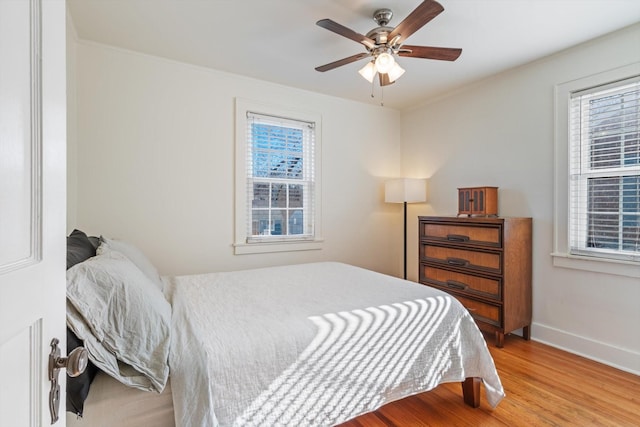 bedroom featuring a ceiling fan, baseboards, and wood finished floors