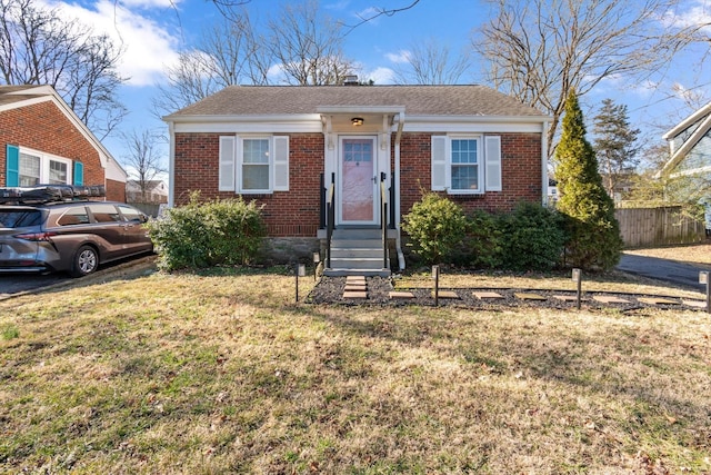 bungalow featuring entry steps, brick siding, and a front lawn