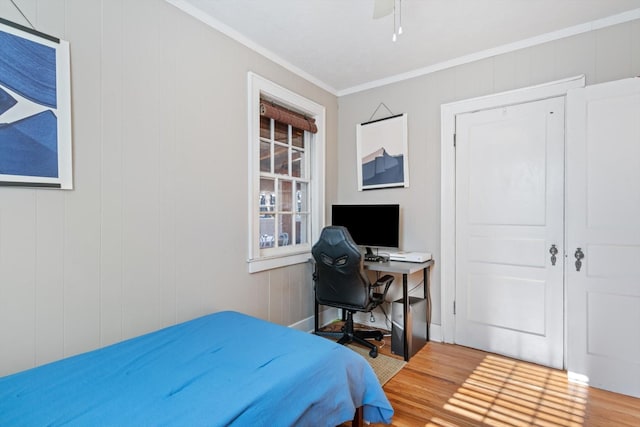 bedroom featuring a ceiling fan, ornamental molding, and wood finished floors