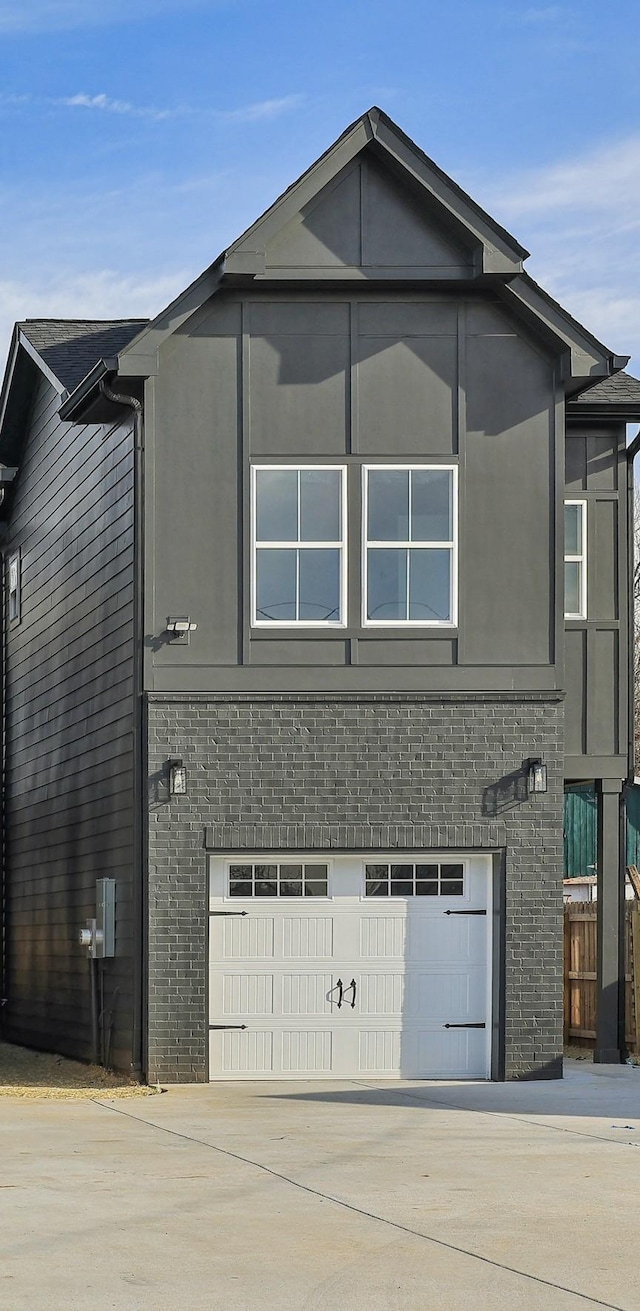 view of side of property with concrete driveway, an attached garage, and stucco siding