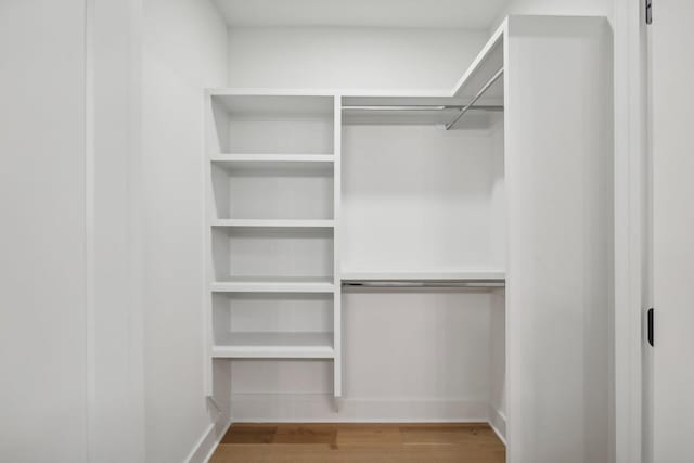 walk in closet with wood finished floors