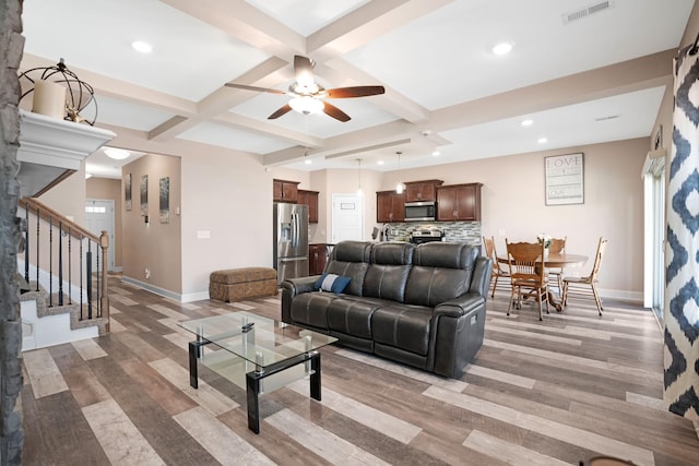 living area featuring visible vents, beam ceiling, coffered ceiling, stairway, and baseboards