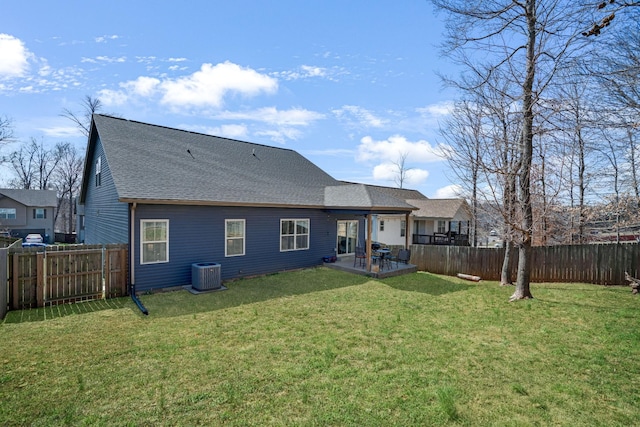 rear view of house with central air condition unit, a yard, a fenced backyard, and a patio area