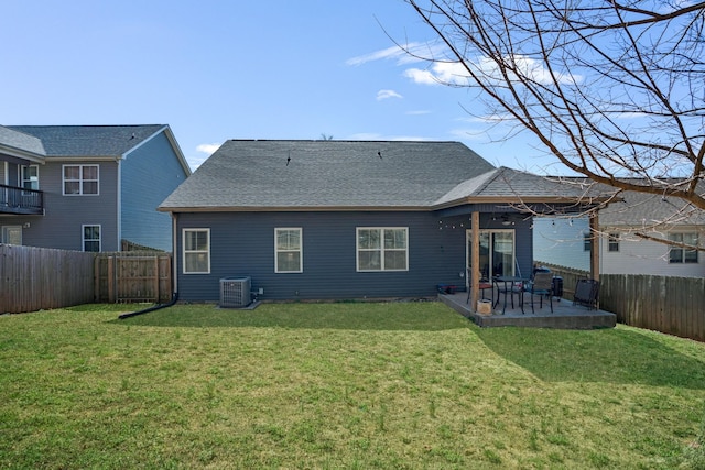 back of property with a fenced backyard, cooling unit, and a yard