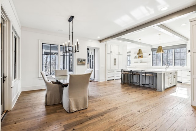 dining area with hardwood / wood-style flooring, baseboards, and beamed ceiling