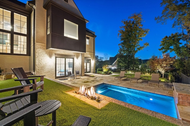 exterior space featuring a patio area, an outdoor fire pit, and a lawn