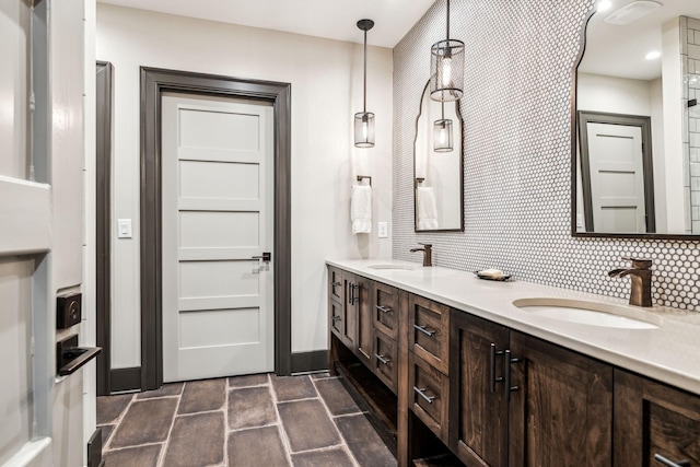 bathroom with double vanity, baseboards, backsplash, and a sink