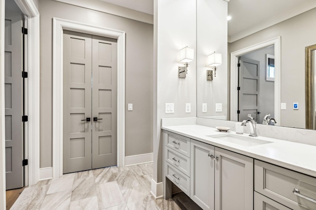 bathroom featuring marble finish floor, vanity, and baseboards