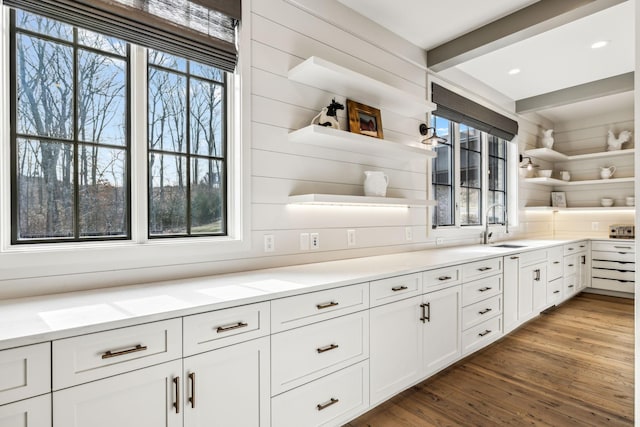 kitchen with wood finished floors, white cabinetry, a wealth of natural light, beam ceiling, and open shelves