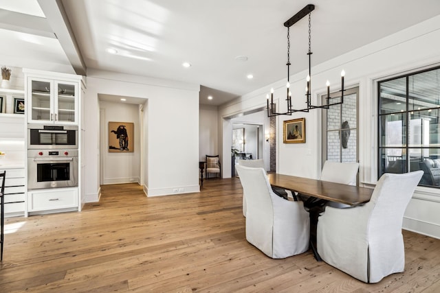 dining space with baseboards, light wood-type flooring, and recessed lighting