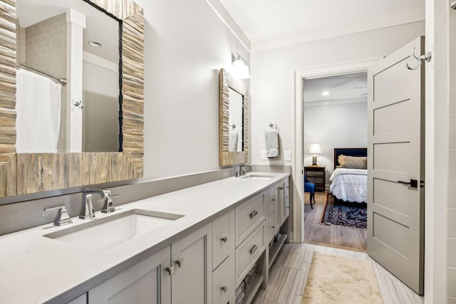 ensuite bathroom featuring curtained shower, a sink, ensuite bath, and double vanity