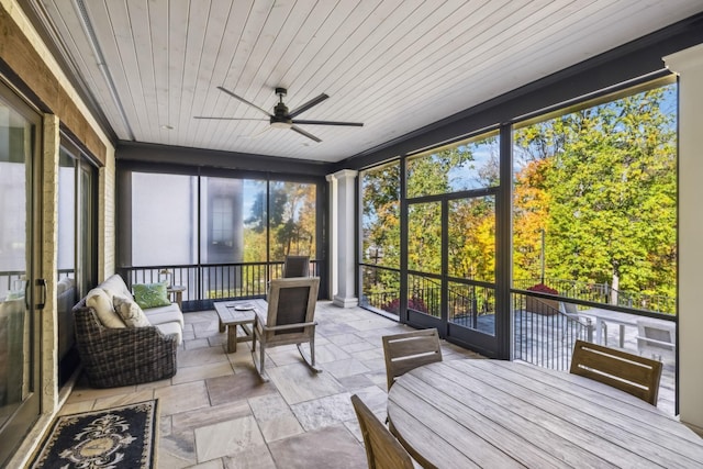 sunroom featuring wood ceiling and a ceiling fan