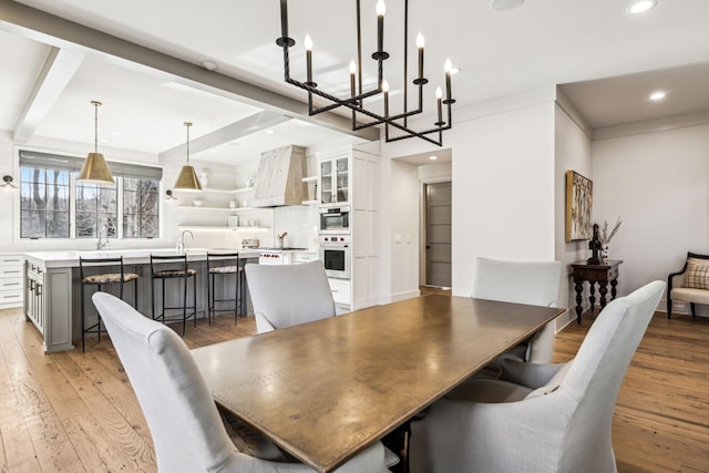 dining room featuring beamed ceiling, light wood-style flooring, and recessed lighting