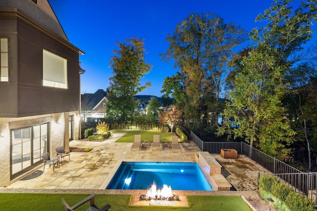 view of swimming pool featuring a fenced backyard, a patio, a fire pit, and a lawn