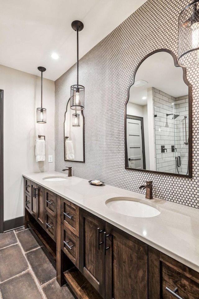 bathroom with double vanity, a sink, stone tile flooring, and a shower stall