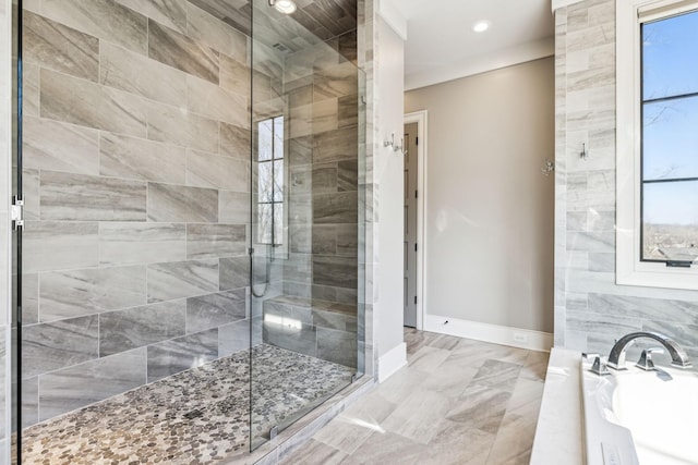 bathroom with baseboards, a tile shower, a bath, and recessed lighting