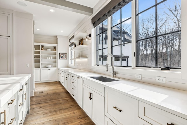 kitchen featuring a sink, light countertops, open shelves, and white cabinets