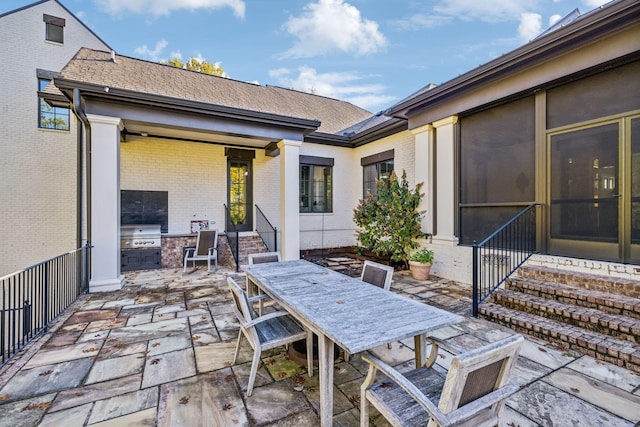 view of patio with entry steps, outdoor dining area, an outdoor kitchen, and a grill