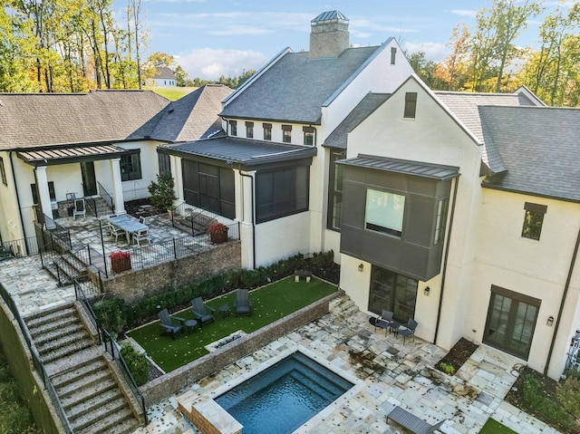 exterior space with metal roof, a patio, a fenced backyard, a sunroom, and a standing seam roof