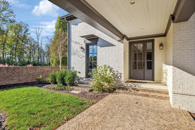 property entrance featuring brick siding and fence