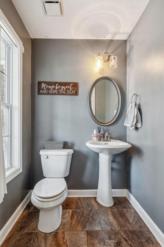 bathroom featuring baseboards, visible vents, and a wealth of natural light