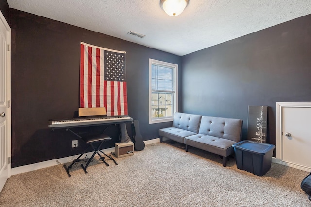 living area with a textured ceiling, carpet, visible vents, and baseboards