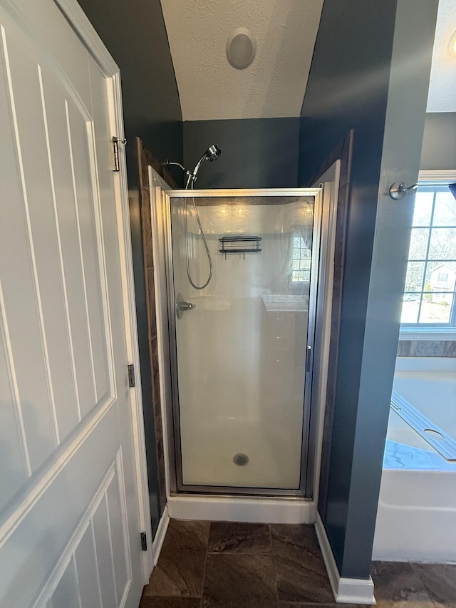 full bath with a stall shower, baseboards, a garden tub, and a textured ceiling