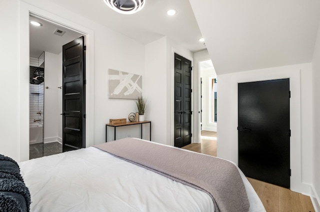 bedroom featuring baseboards, ensuite bathroom, dark wood-style flooring, and recessed lighting